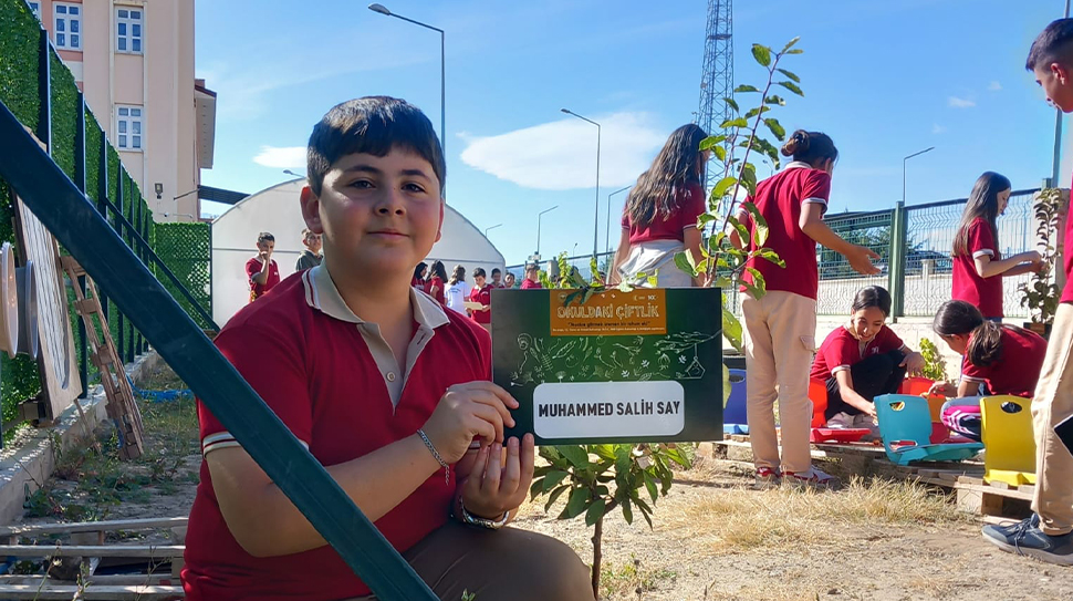Minik eller toprağa dokunuyor, üretmenin mutluluğunu yaşıyor. “Okuldaki Çiftlik” projesiyle